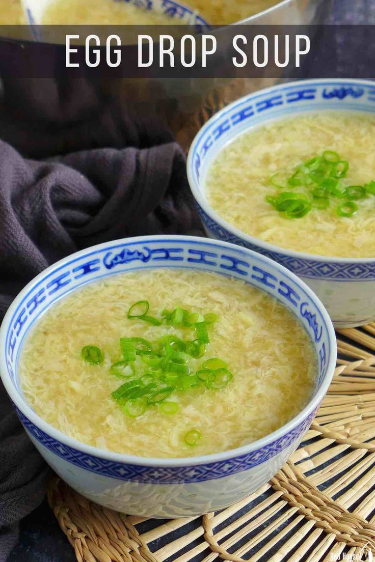 two blue and white bowls filled with egg drop soup