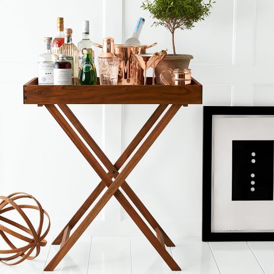 a wooden table with bottles on it next to a framed photograph and a vase filled with flowers