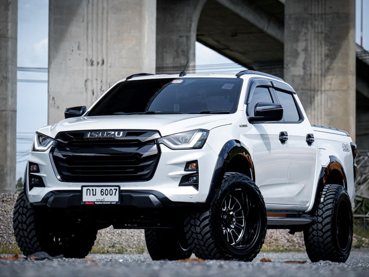 a white truck parked in front of a bridge