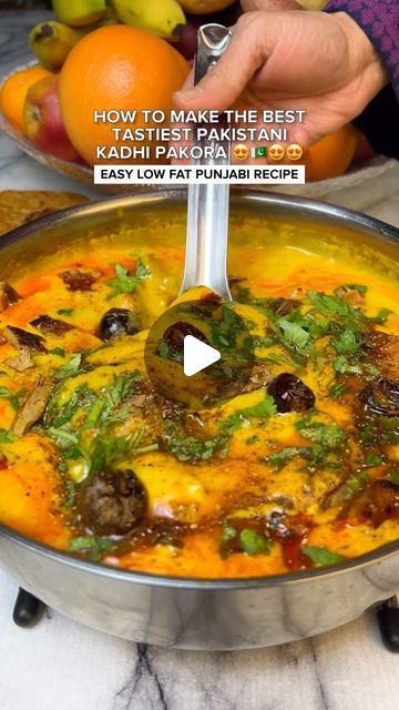 a pan filled with food sitting on top of a table next to oranges and other fruits