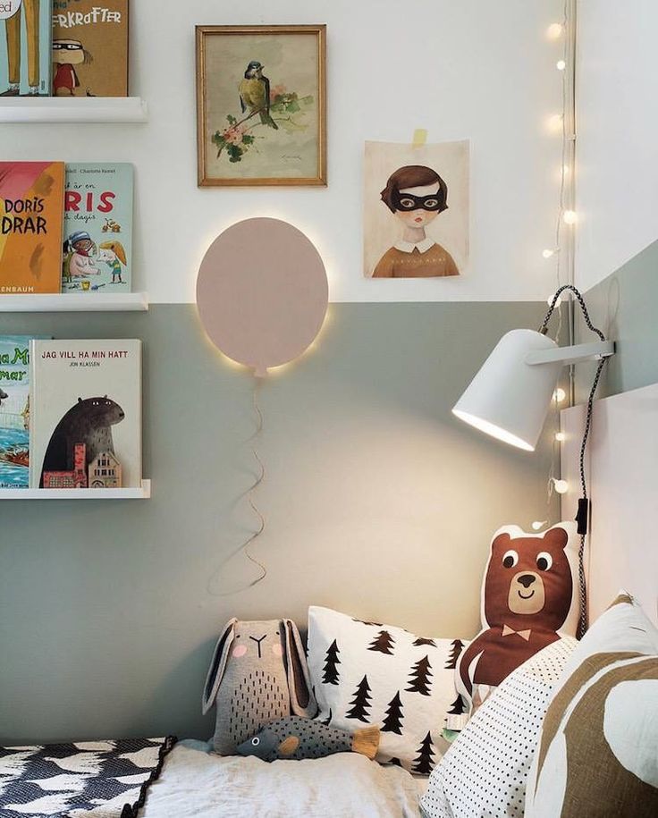 a bedroom with pictures on the wall and a teddy bear sitting on the bed in front of it