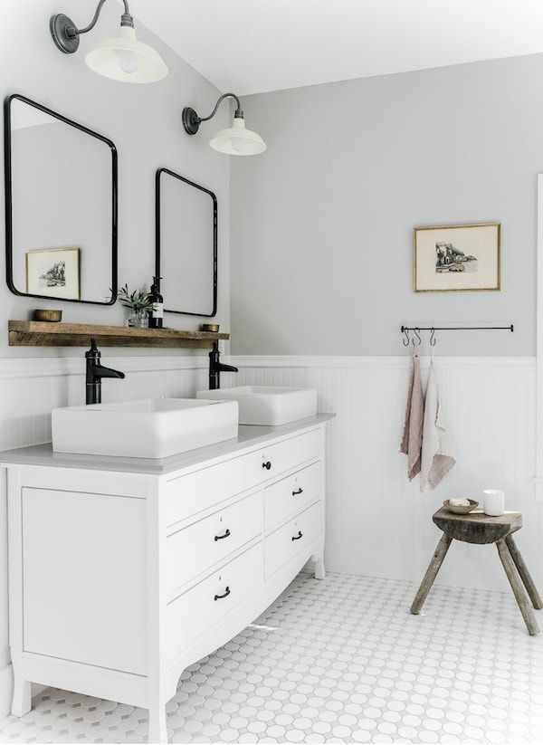 a white bathroom with two sinks and mirrors