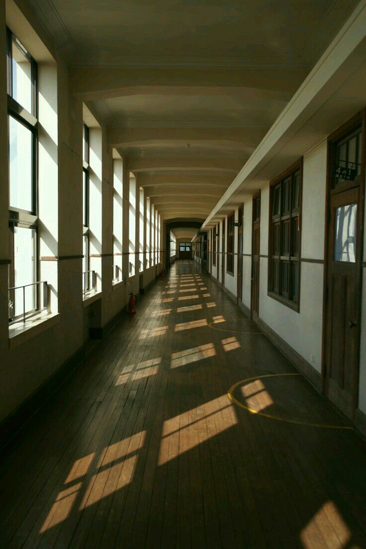 the sun shines through large windows in an empty building