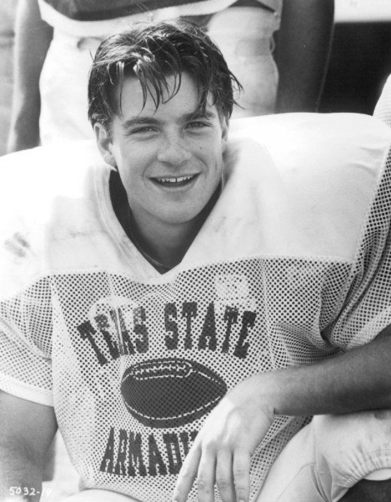 a young man sitting on top of a football field