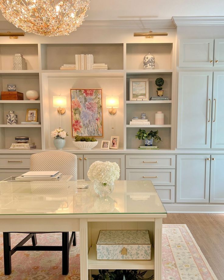 a white desk sitting under a chandelier in a living room