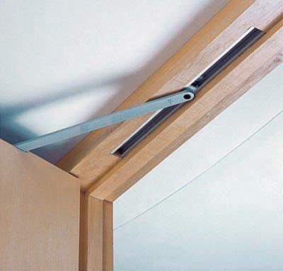 a pair of scissors sticking out of the side of a wooden door frame with white walls in the background