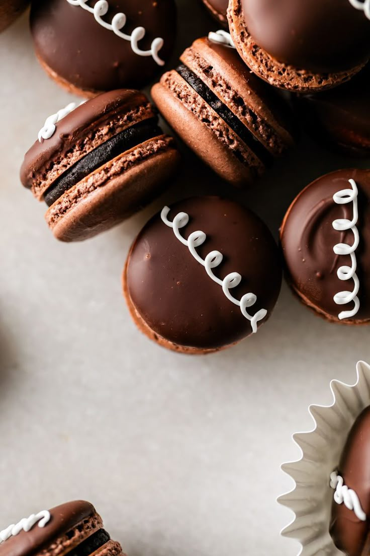 chocolate covered cookies with white frosting and football decorations