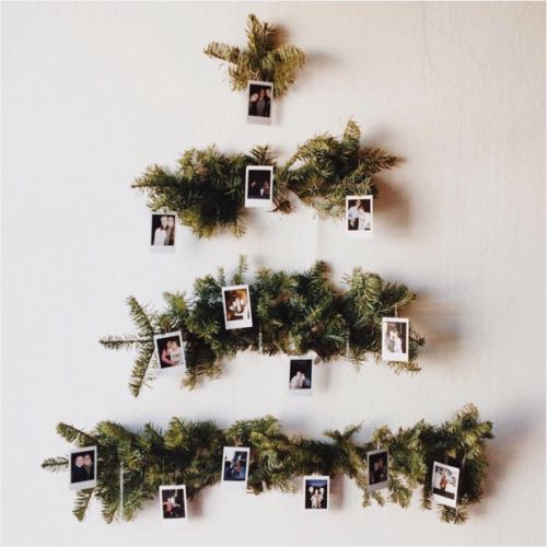 a christmas tree made out of photos hanging on the wall