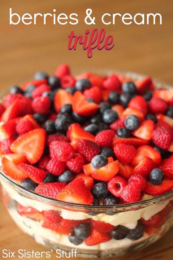 berries and cream trifle in a glass bowl on a wooden table with text overlay