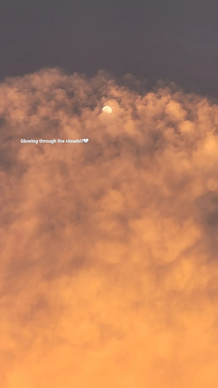 an airplane flying in the sky above some clouds