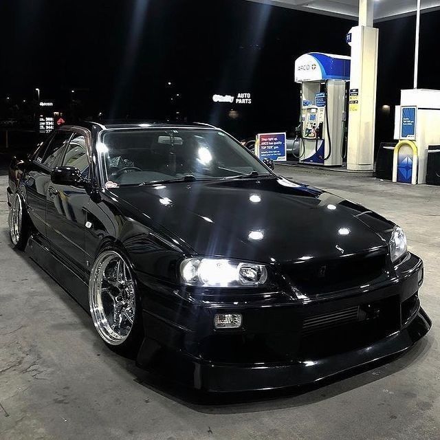 a black car parked in front of a gas station