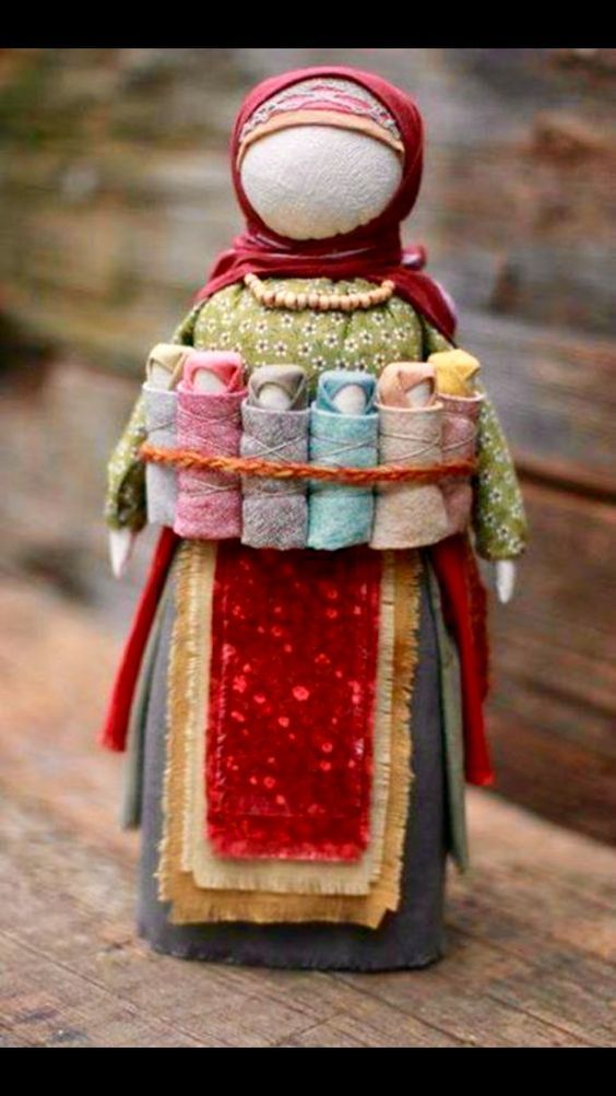 a small doll is sitting on top of a piece of fabric and has many things in it