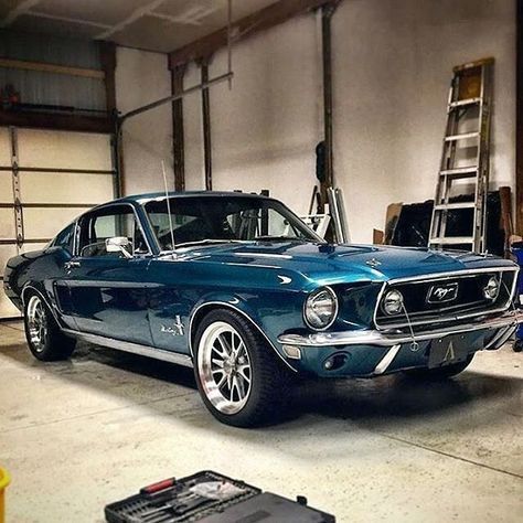 an old blue mustang in a garage