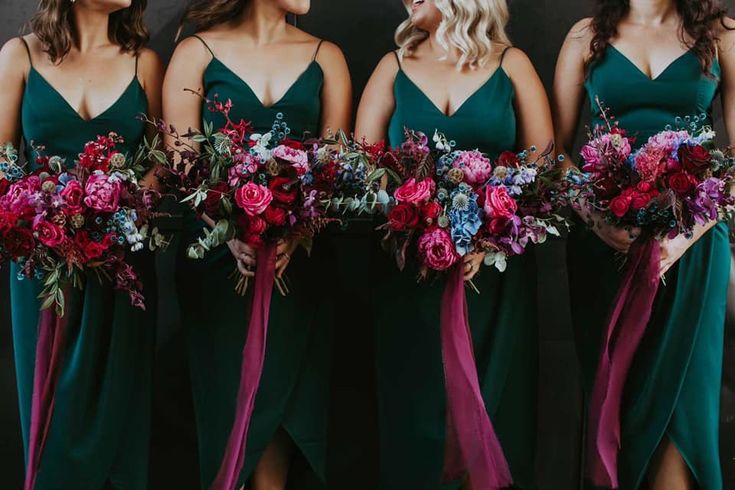 the bridesmaids are wearing green dresses with purple and red flowers in their bouquets