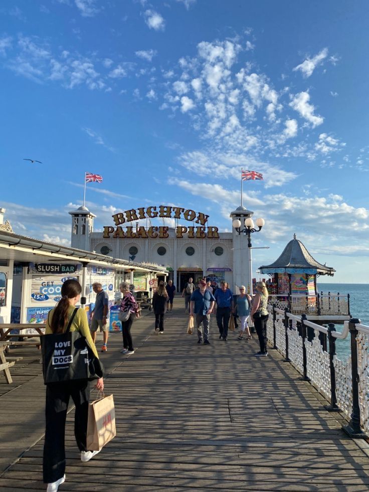 people are walking on the pier near the water