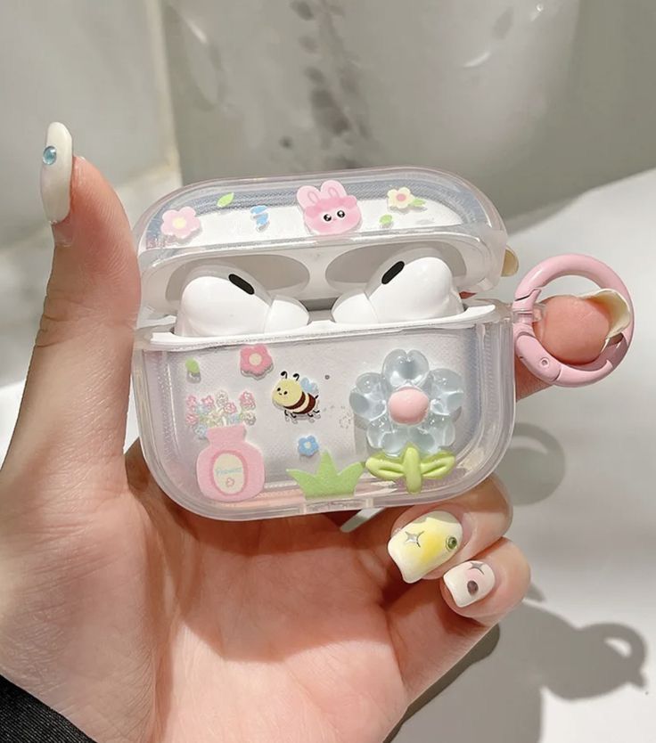 a hand holding an air freshener case filled with little animals and eggs in it