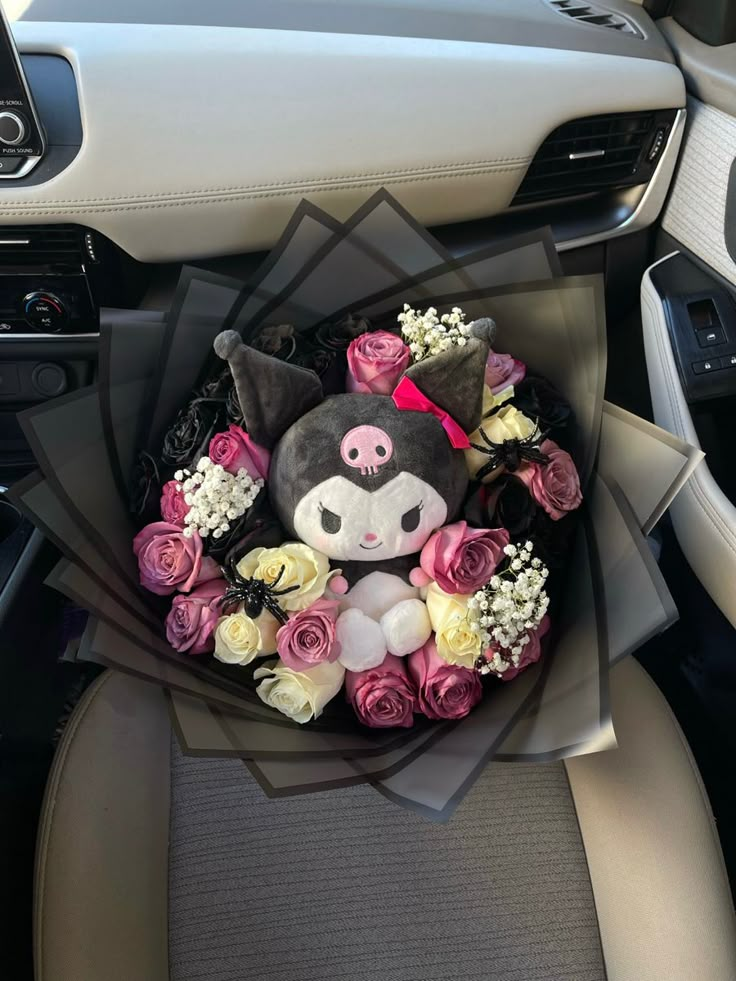 a bouquet of flowers in the center of a car's dashboard with a stuffed animal