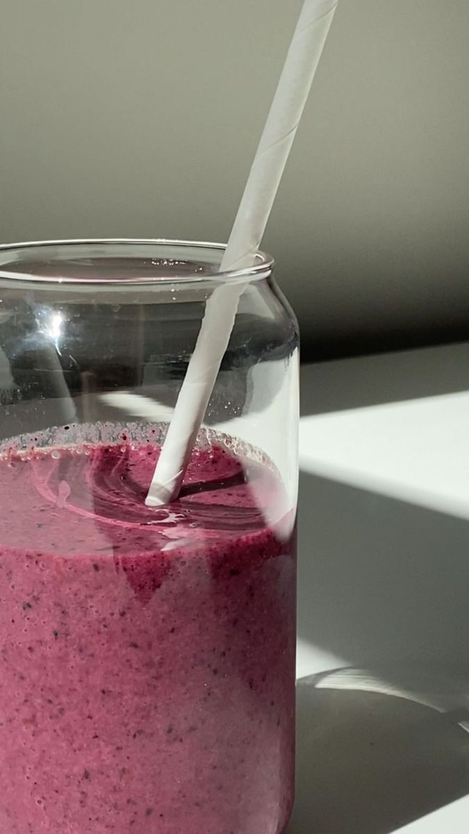 a smoothie in a jar with a straw sticking out of it