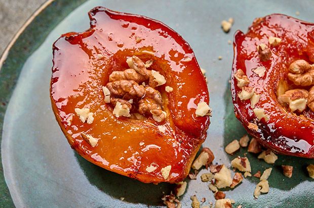 two pieces of tomato on a plate with walnuts