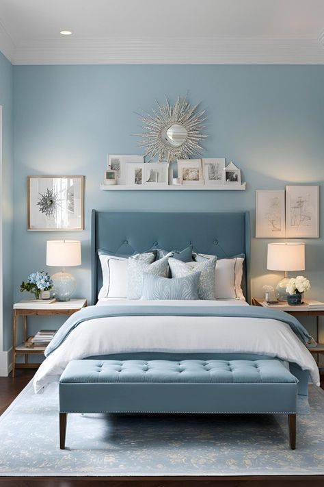 a bedroom with blue walls, white bedding and pictures on the wall above it