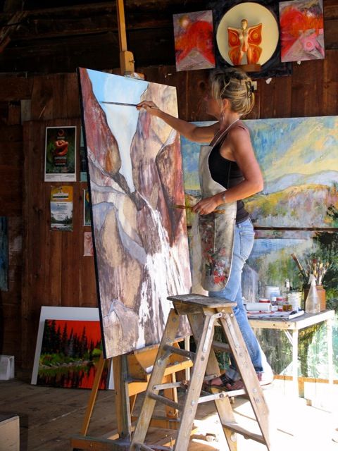 a woman is painting in an art studio