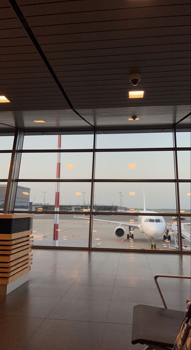 an airplane is parked at the airport terminal as it sits on the tarmac with its windows open