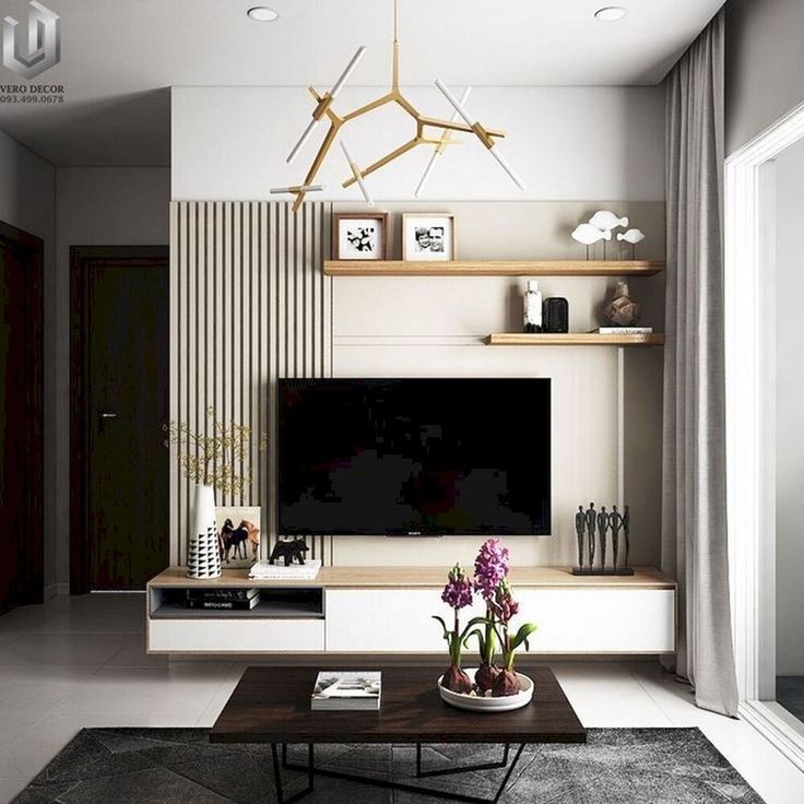 a living room with a tv and some plants on the coffee table in front of it