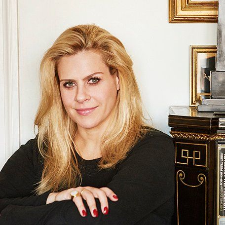 a woman sitting in front of a clock with her arms crossed