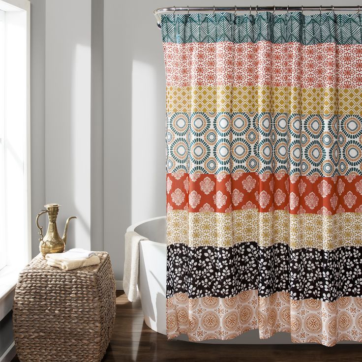 a colorful shower curtain in a bathroom next to a basket with a vase on it