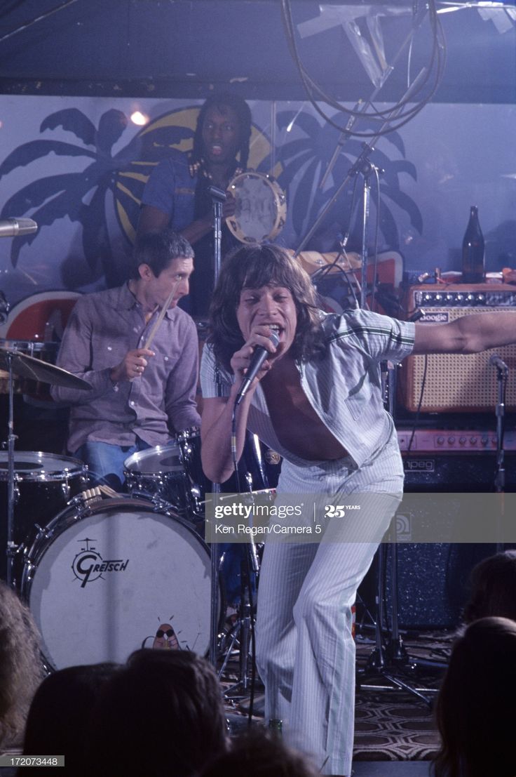 the rolling stones performing on stage in front of an audience at a concert, circa 1970