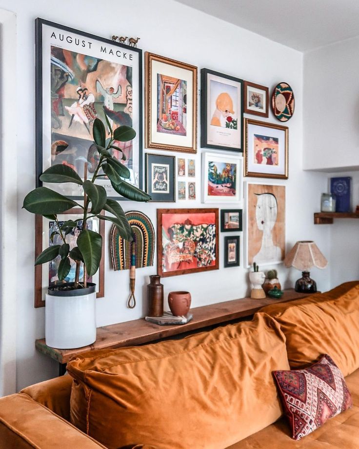 a living room filled with lots of pictures on the wall and a couch in front of it