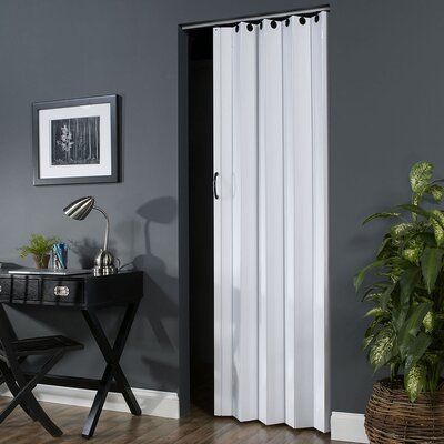 a black and white sliding door in a living room next to a table with a potted plant on it