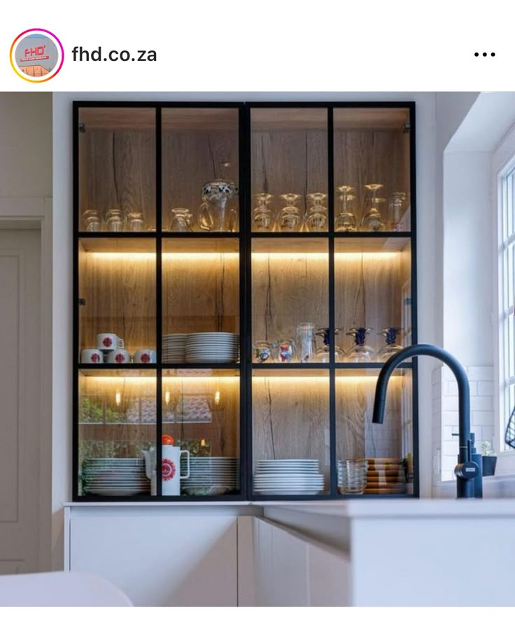 an open cabinet in the kitchen is filled with dishes