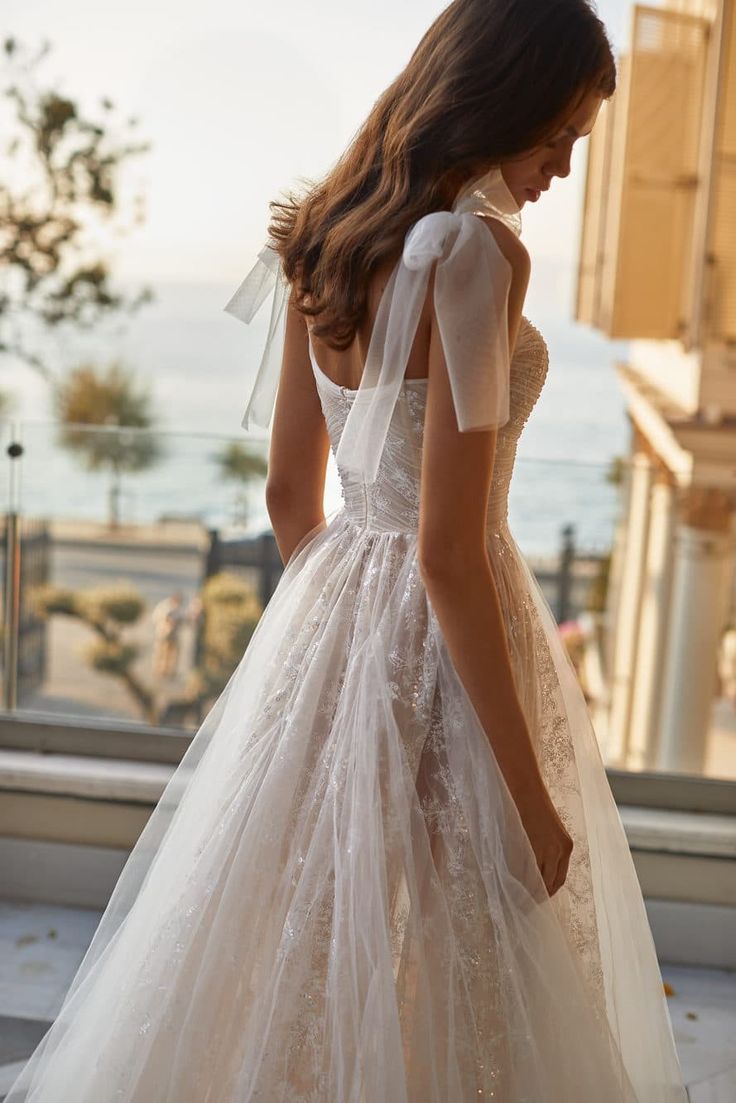 a woman in a wedding dress looking down