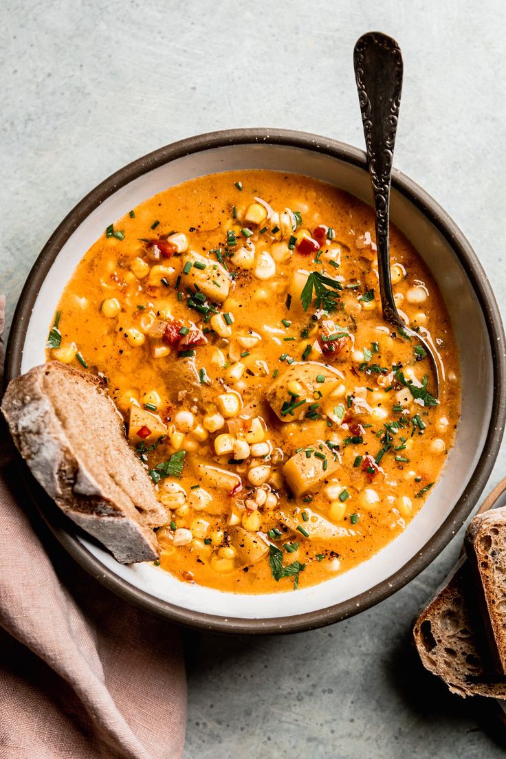 a bowl filled with soup next to some bread