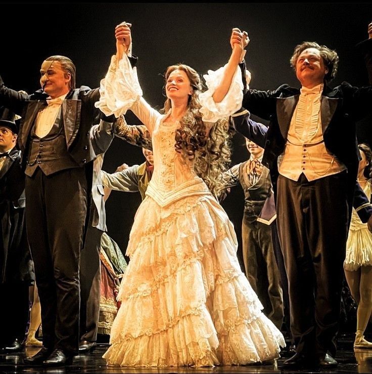 a group of people standing on top of a stage with their arms in the air