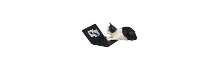 a small white and black dog laying on top of a laptop computer keyboard with the letter e in front of it