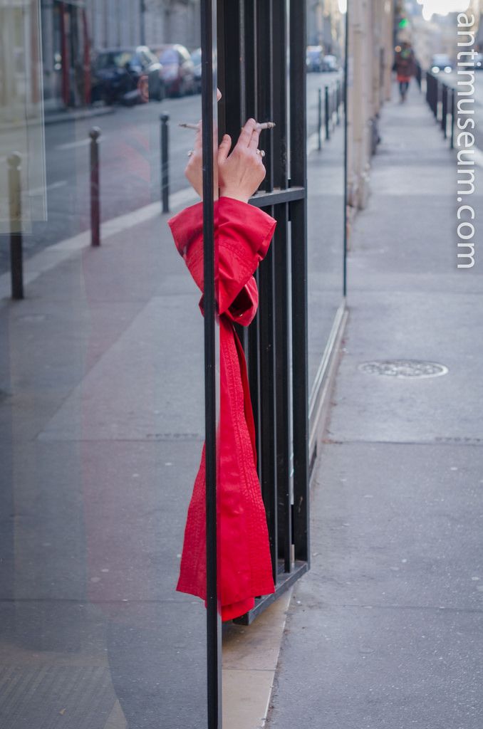 a person standing on the sidewalk with their cell phone