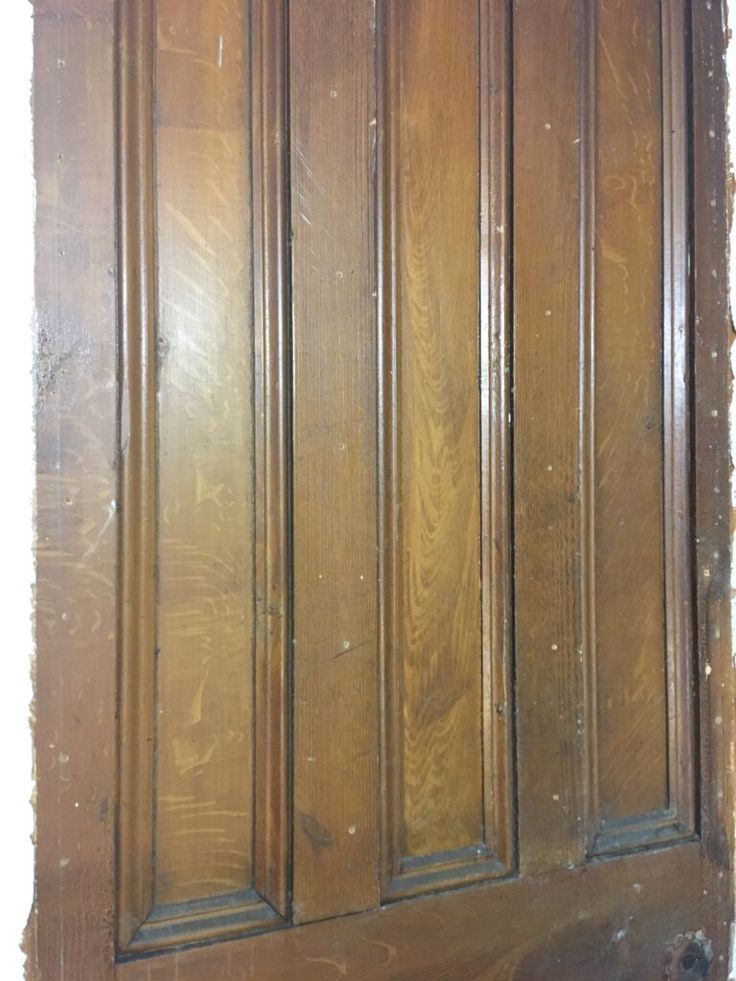 an old wooden door with peeling paint on the bottom and side paneling around it