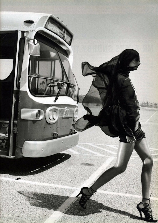 a woman in high heels walking towards a bus