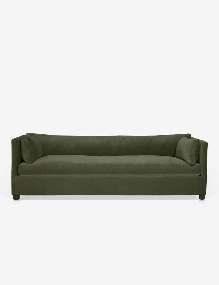 a green couch sitting on top of a white floor