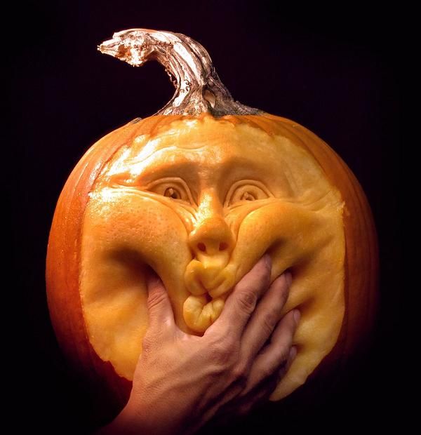 a pumpkin with a face carved into it's mouth and hands holding the top