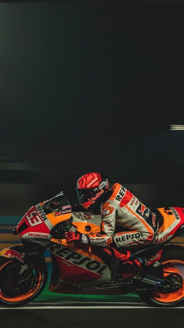 a man riding on the back of a motorcycle down a street