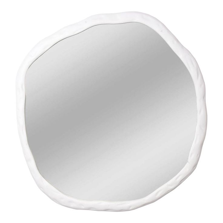 a white round mirror sitting on top of a wall