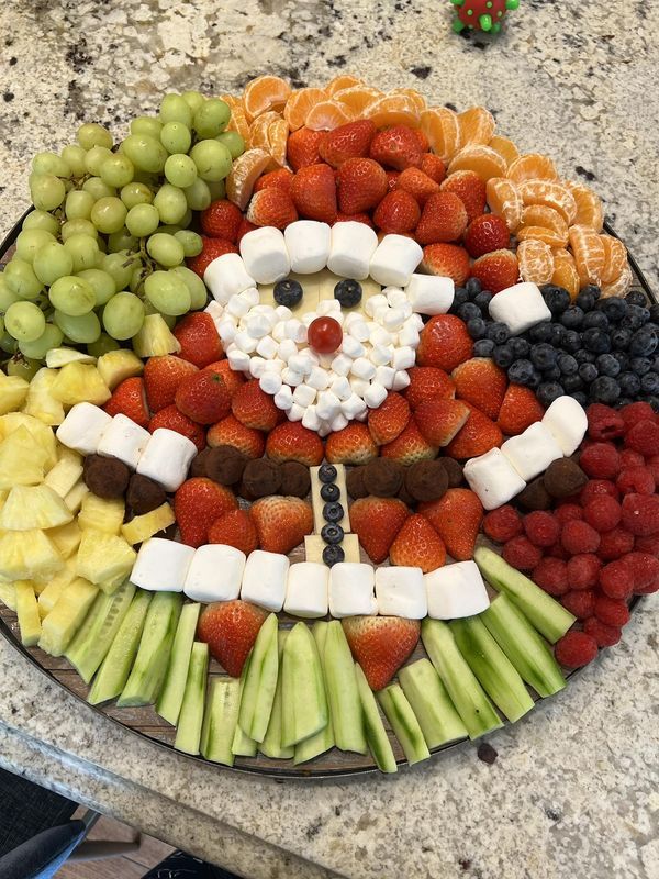 a platter filled with fruit and veggies in the shape of santa clause