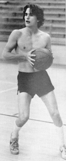 a shirtless man holding a basketball on a court