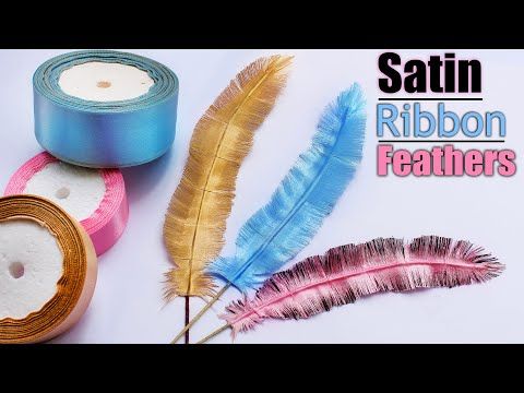 three different colored feathers sitting on top of each other next to a tape and candle