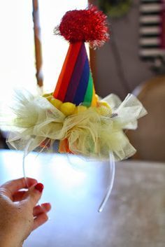 a person is holding a wine glass with a colorful hat on it and a red pom - pom at the top