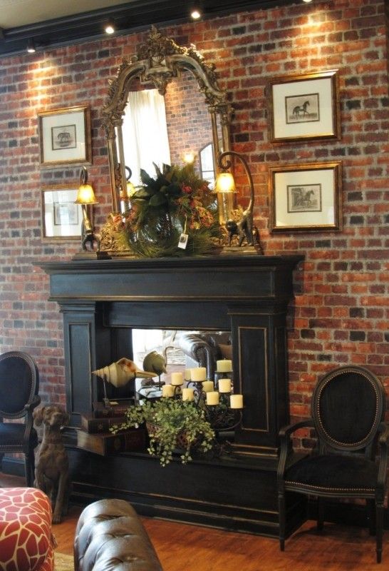 a living room filled with furniture and a fire place in front of a brick wall