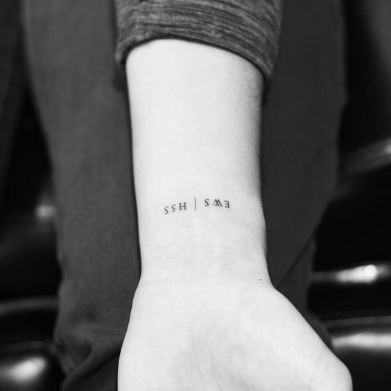 a person with a small tattoo on their wrist that says, she said i love you